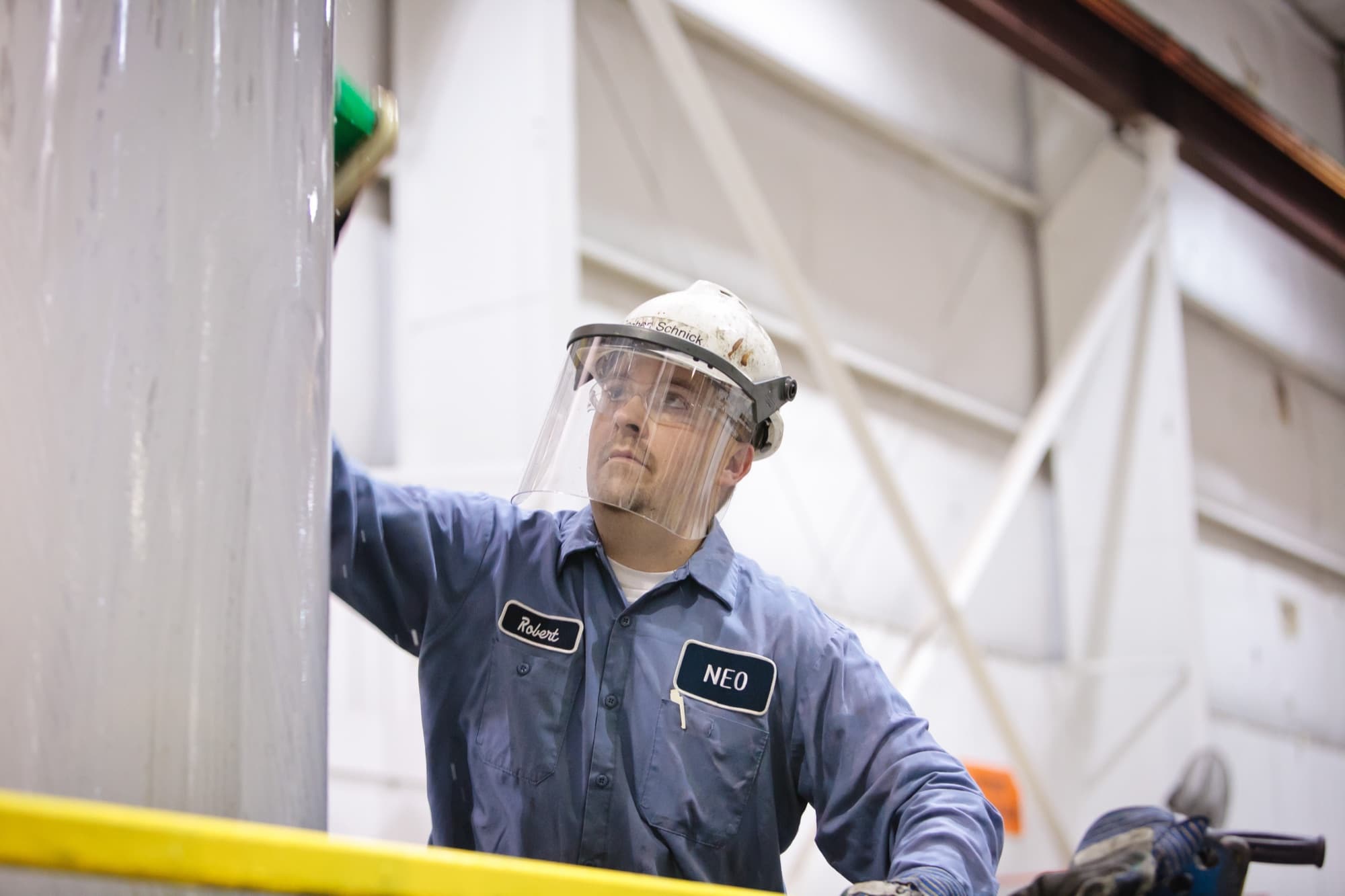 NEO worker with a face shield in the hall