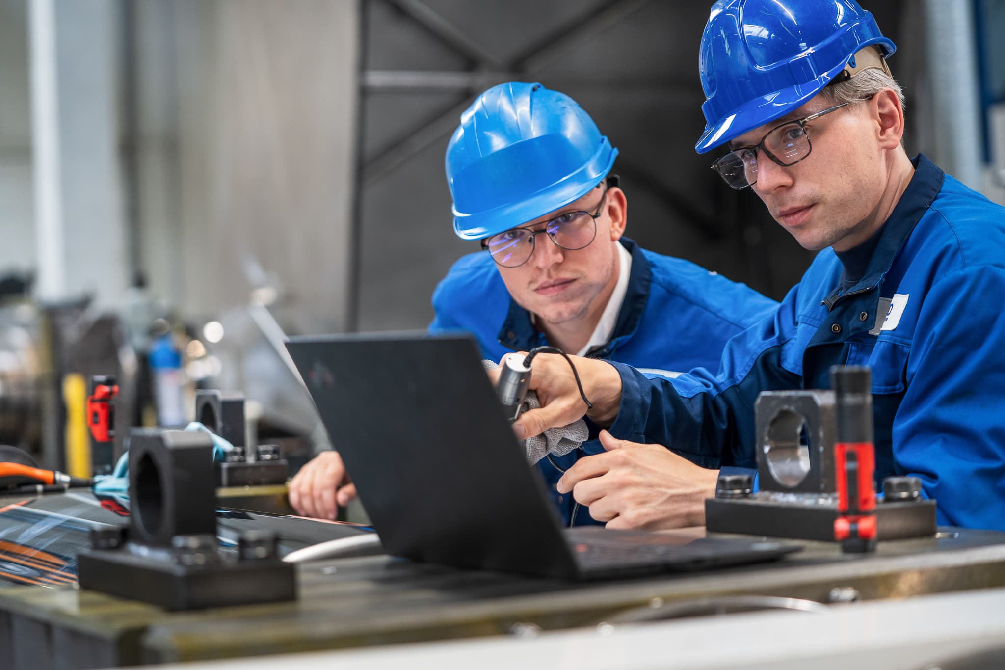 Two NEO technicians checking a measurement on a laptop